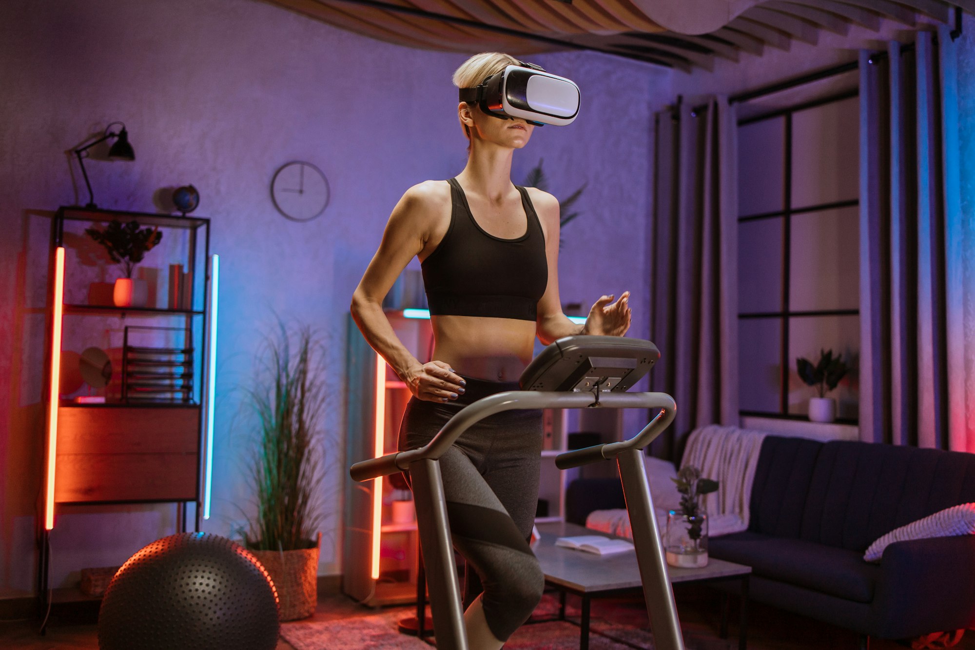 Caucasian woman doing fitness exercise, running on treadmill using virtual reality glasses