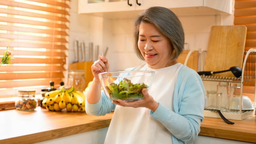 mature and old adult woman takes on the role of a skilled cooking salad.