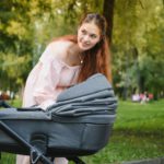 Mother with baby carriage in the park