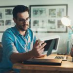 Shot of a young businessman looking at a photo frame while working in his office